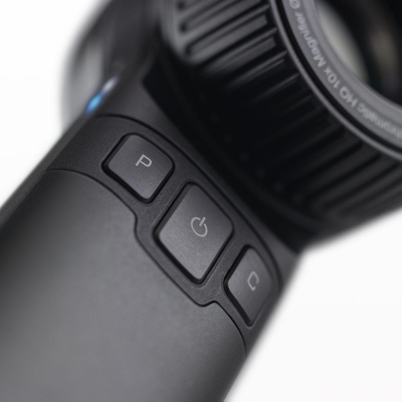 The image shows a close-up view of the HEINE DELTA 30 PRO dermatoscope. The device features a textured grip and clearly labeled buttons for easy operation, designed for precise skin examination.